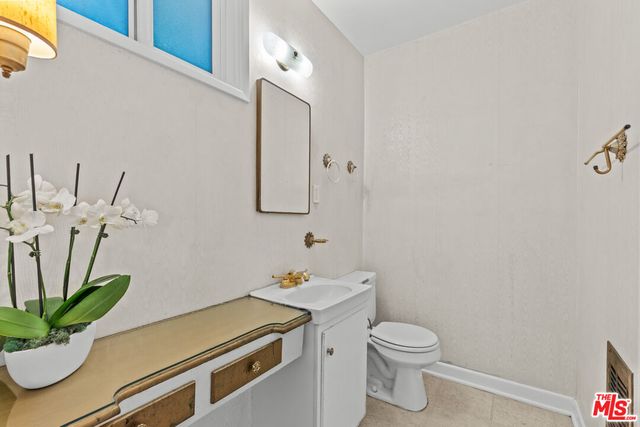 a bathroom with a sink a toilet and a mirror