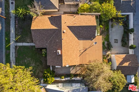 an aerial view of a house with a yard and large trees