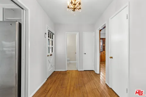 a view of a room with wooden floor and a hallway