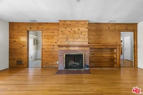 a view of empty room with wooden floor and fireplace
