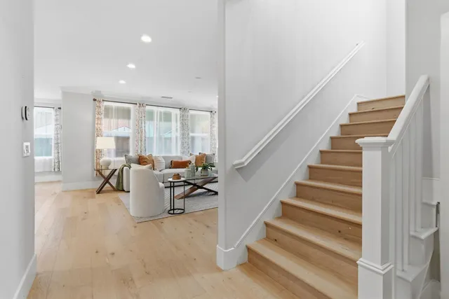 a living room with furniture wooden floor and a large window