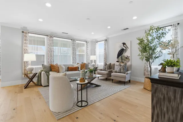 a living room with furniture a dining table a rug and kitchen view