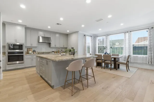 a kitchen with granite countertop white cabinets and a stainless steel appliances