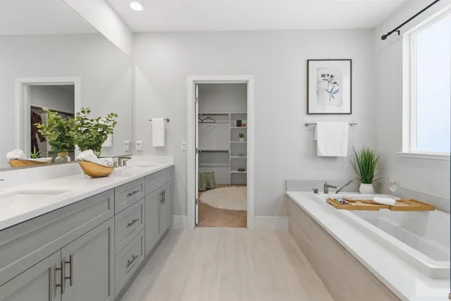 a spacious bathroom with a tub shower and a sink