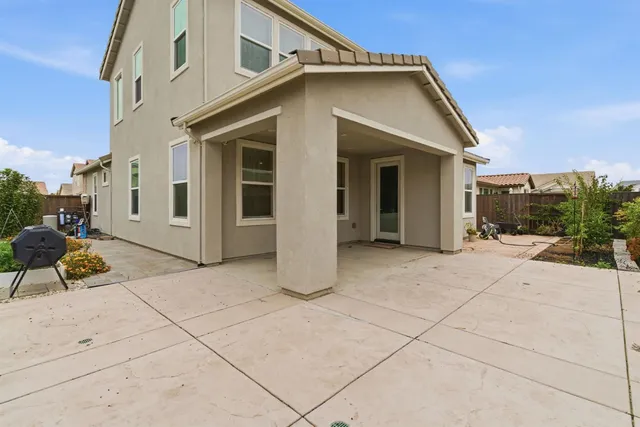 a front view of a house with a yard and potted plants