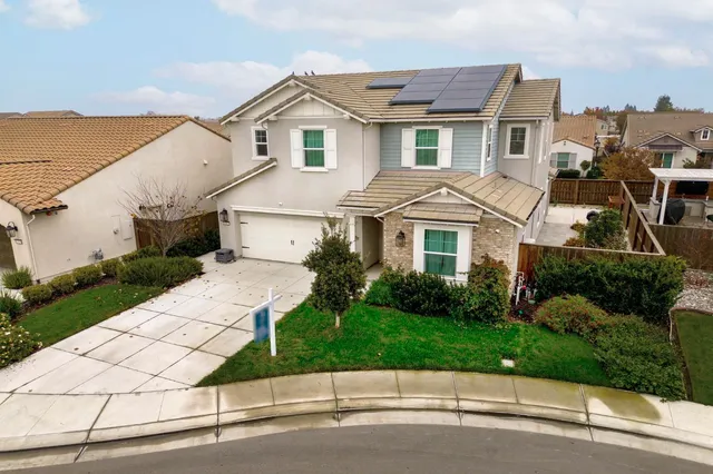 an aerial view of a house with a swimming pool and a yard