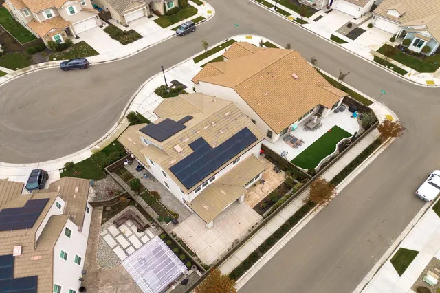 an aerial view of a house with yard swimming pool and ocean view