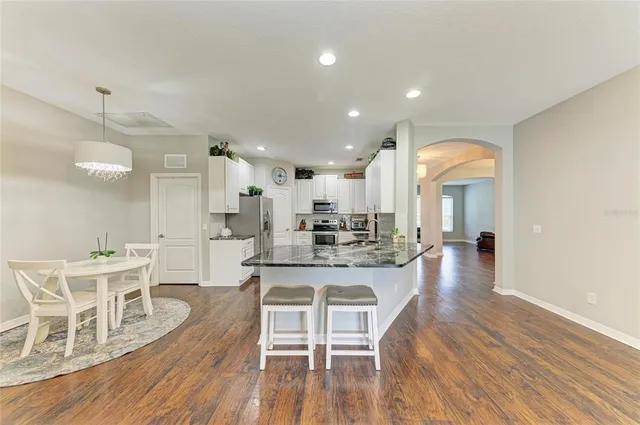 a kitchen with stainless steel appliances granite countertop a refrigerator a stove and a cabinets