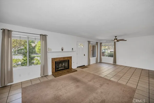 a view of an empty room with a fireplace and a window