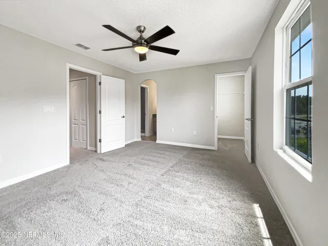 a view of a livingroom with a ceiling fan and window