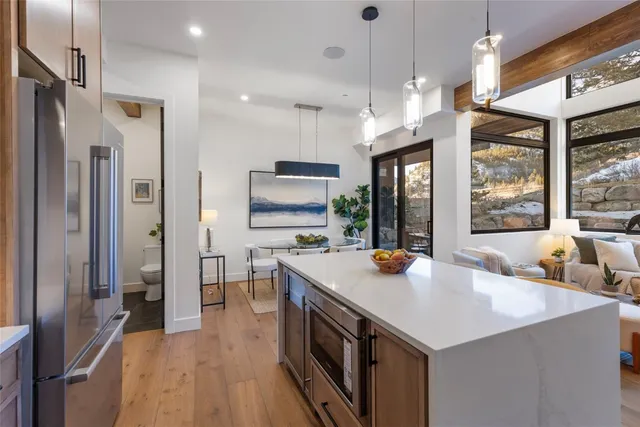 a kitchen with sink a refrigerator and chairs
