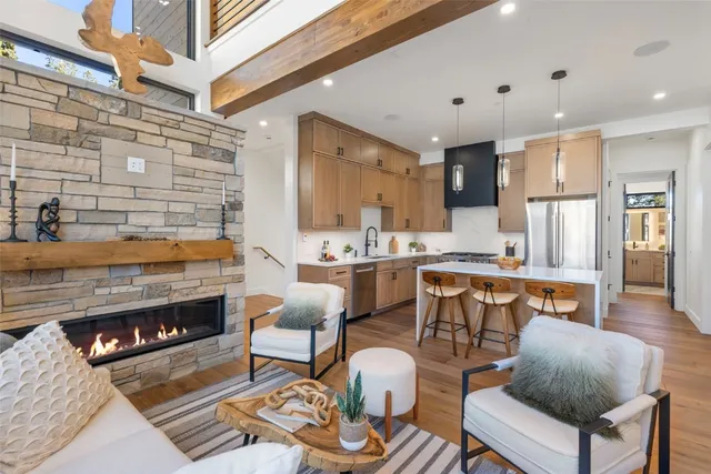 a living room with stainless steel appliances kitchen island granite countertop furniture and a fireplace