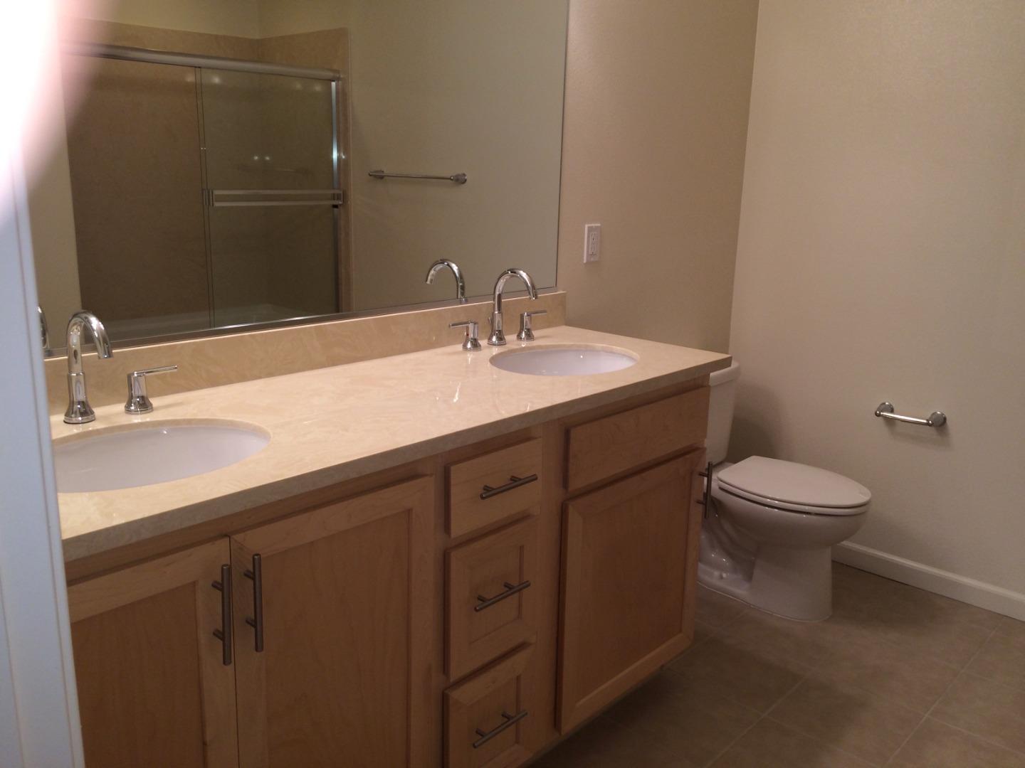695 Elderberry Drive Milpitas, CA 95035 - Photo 17 of 22 a bathroom with a granite countertop sink a toilet and a mirror