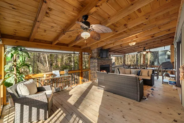 a view of a patio with couches chairs and wooden floor