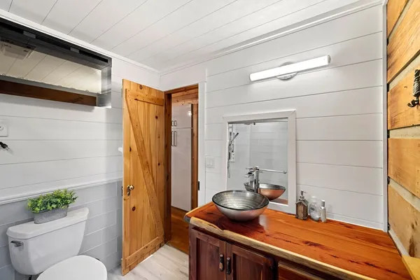 a bathroom with a granite countertop sink a toilet and shower