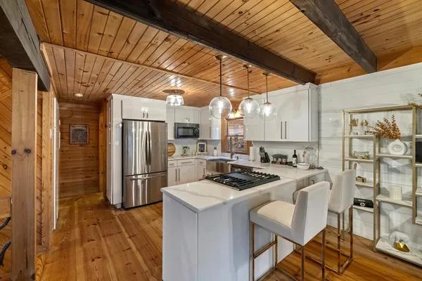 a kitchen that has a refrigerator a stove a sink dishwasher with a dining table and chairs