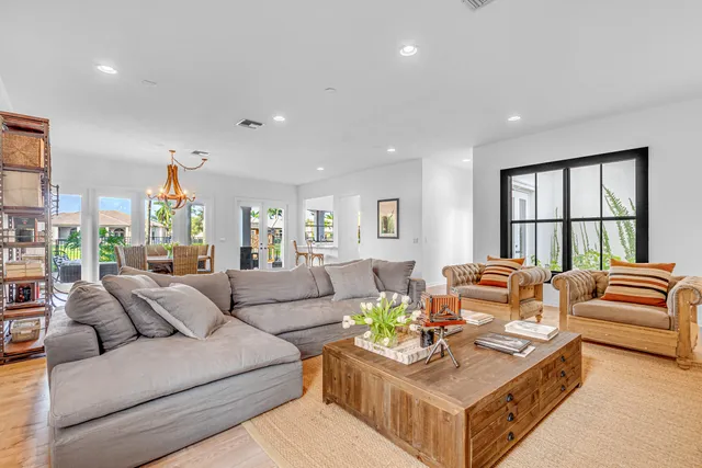a living room with furniture kitchen view and a large window