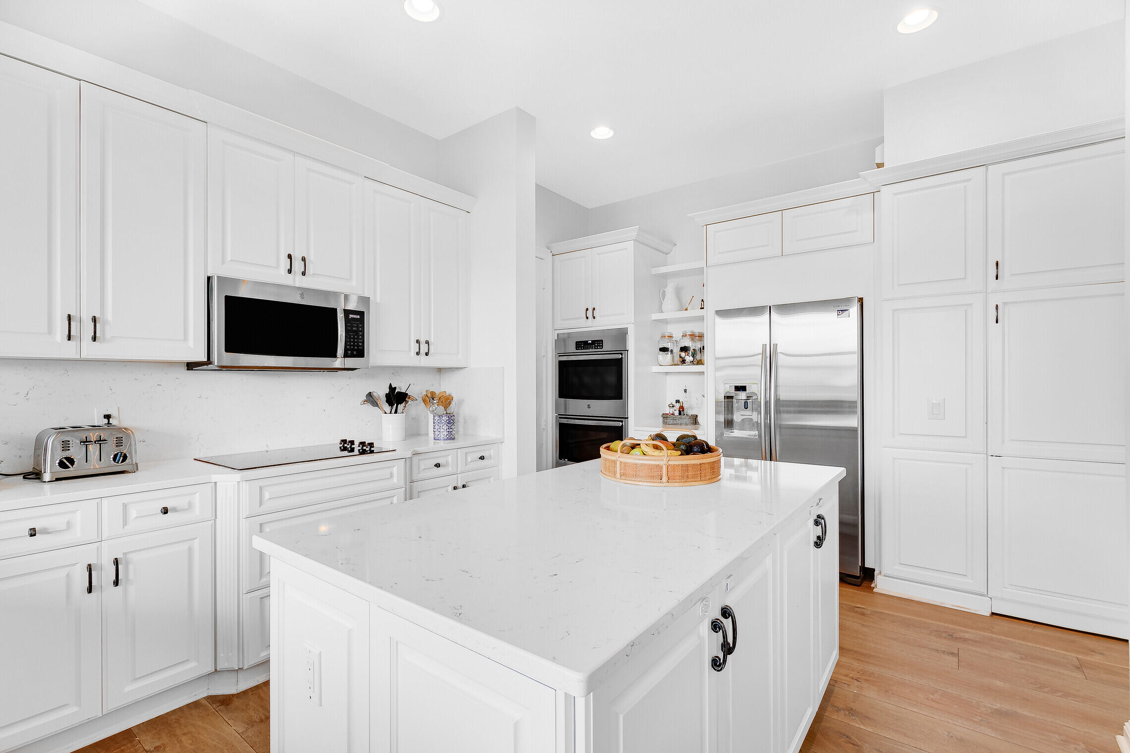 11663 Sunrise View Lane Wellington, FL 33449 - Photo 21 of 43 a white kitchen with stainless steel appliances a stove a sink a refrigerator a white counter tops and white cabinets