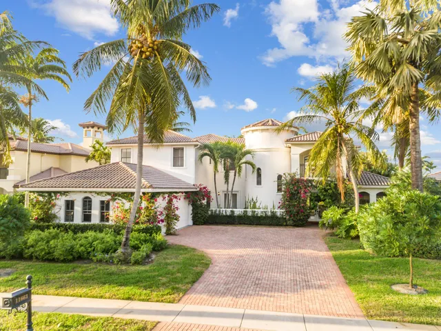 a front view of a house with a yard and potted plants