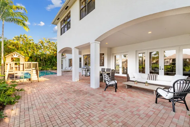 a view of a swimming pool with lawn chairs under an umbrella