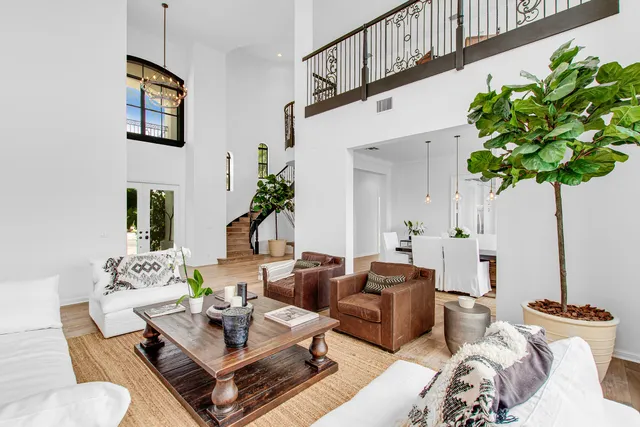 a living room with furniture a chandelier and a potted plant