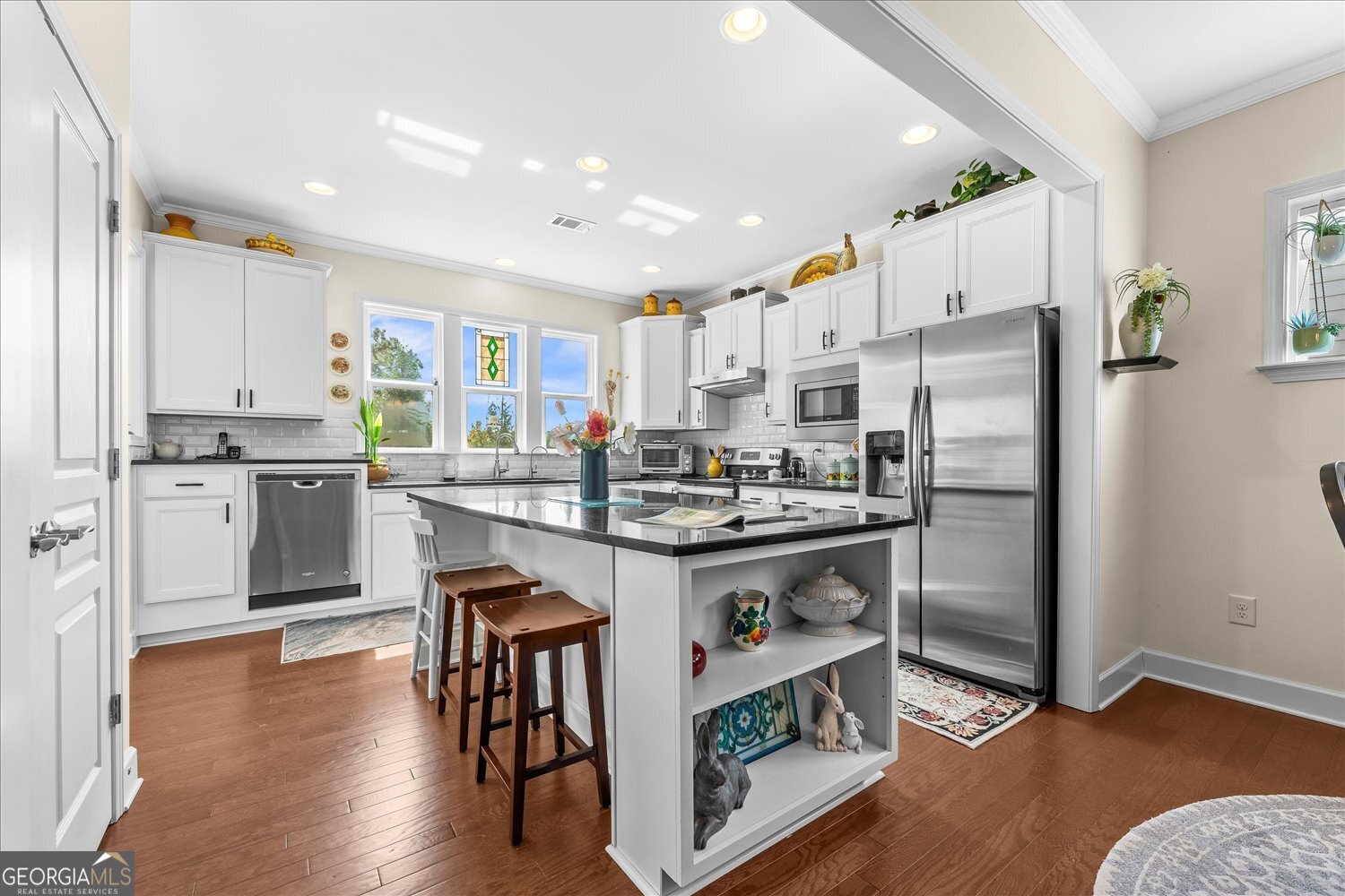 1071 Southern Pne Road Greensboro, GA 30642 - Photo 22 of 48 a kitchen with kitchen island granite countertop wooden floors and stainless steel appliances
