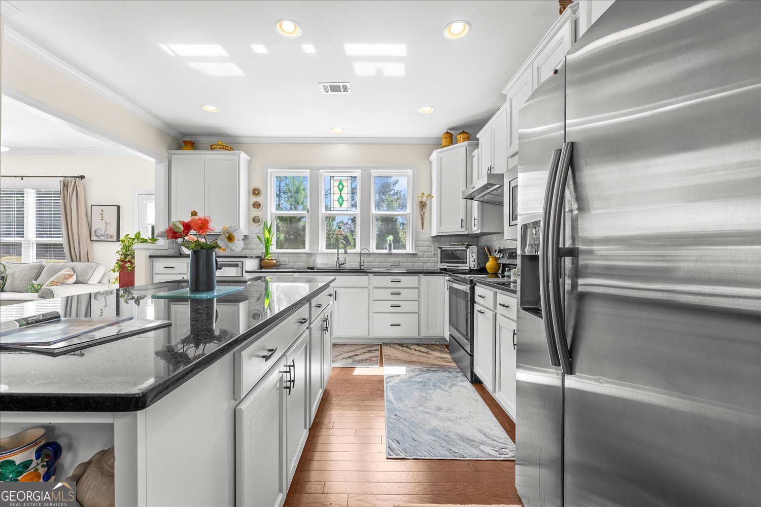 1071 Southern Pne Road Greensboro, GA 30642 - Photo 24 of 48 a kitchen with stainless steel appliances granite countertop a refrigerator a sink dishwasher a stove and white countertops with wooden floor
