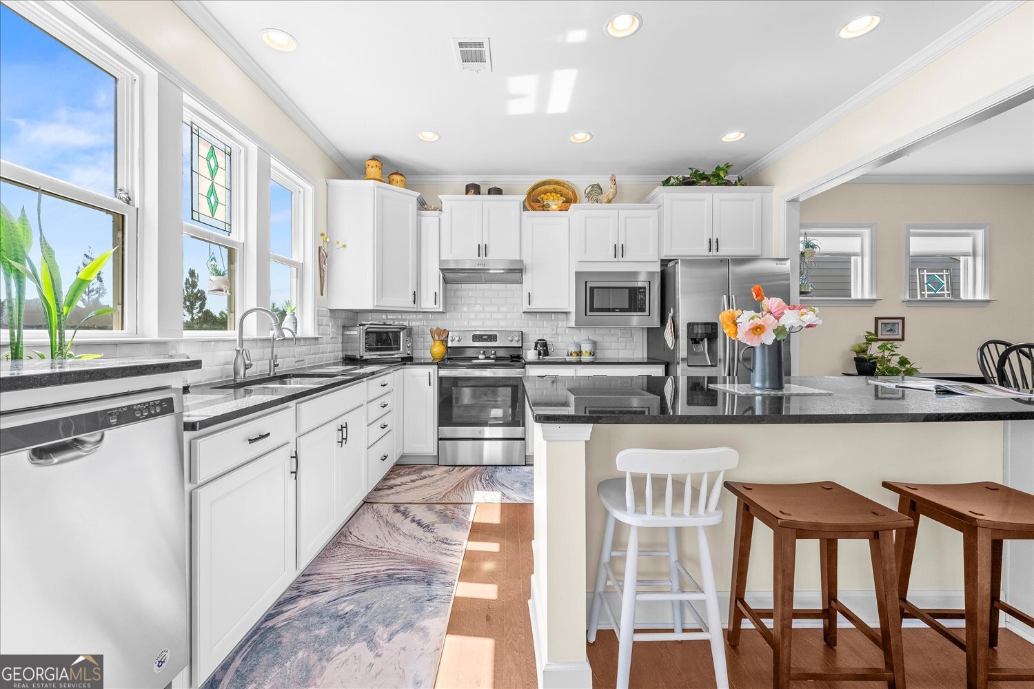 1071 Southern Pne Road Greensboro, GA 30642 - Photo 26 of 48 a kitchen with stainless steel appliances granite countertop a stove top oven a sink a dining table and chairs