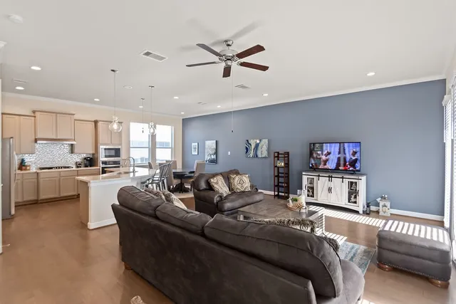 a living room with a couch and a ceiling fan