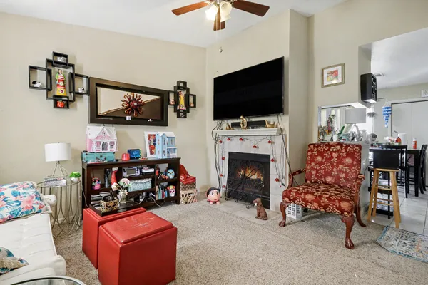 a living room with furniture a flat screen tv and a fireplace