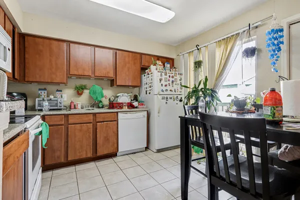 a kitchen with stainless steel appliances kitchen island granite countertop a refrigerator a microwave a sink and white cabinets