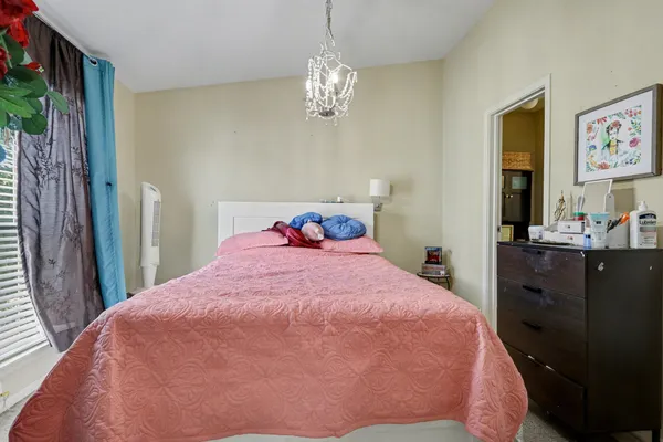 a bedroom with a bed and a chandelier