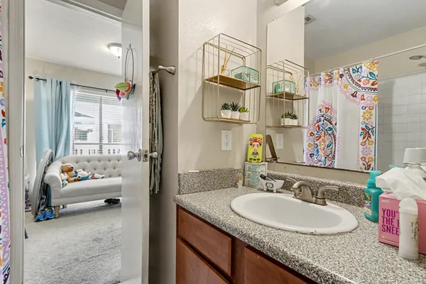 a bathroom with a granite countertop tub sink and mirror