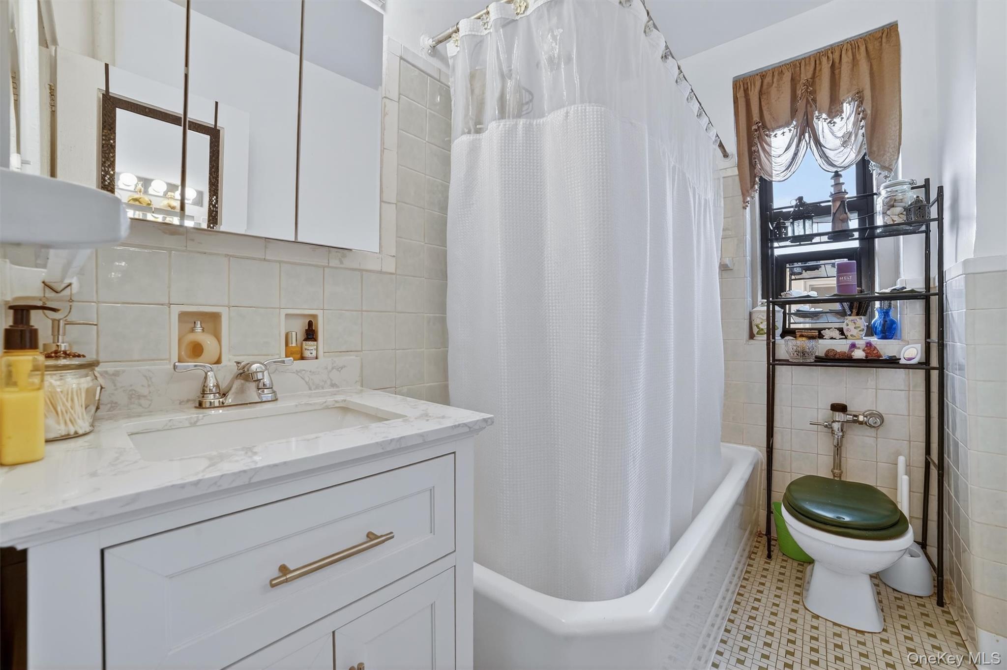 2962 Decatur Avenue, Unit 5 Bronx, NY 10458 - Photo 12 of 17 a bathroom with a sink a toilet and a mirror