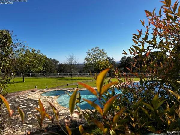 a view of a swimming pool with a yard and sitting area