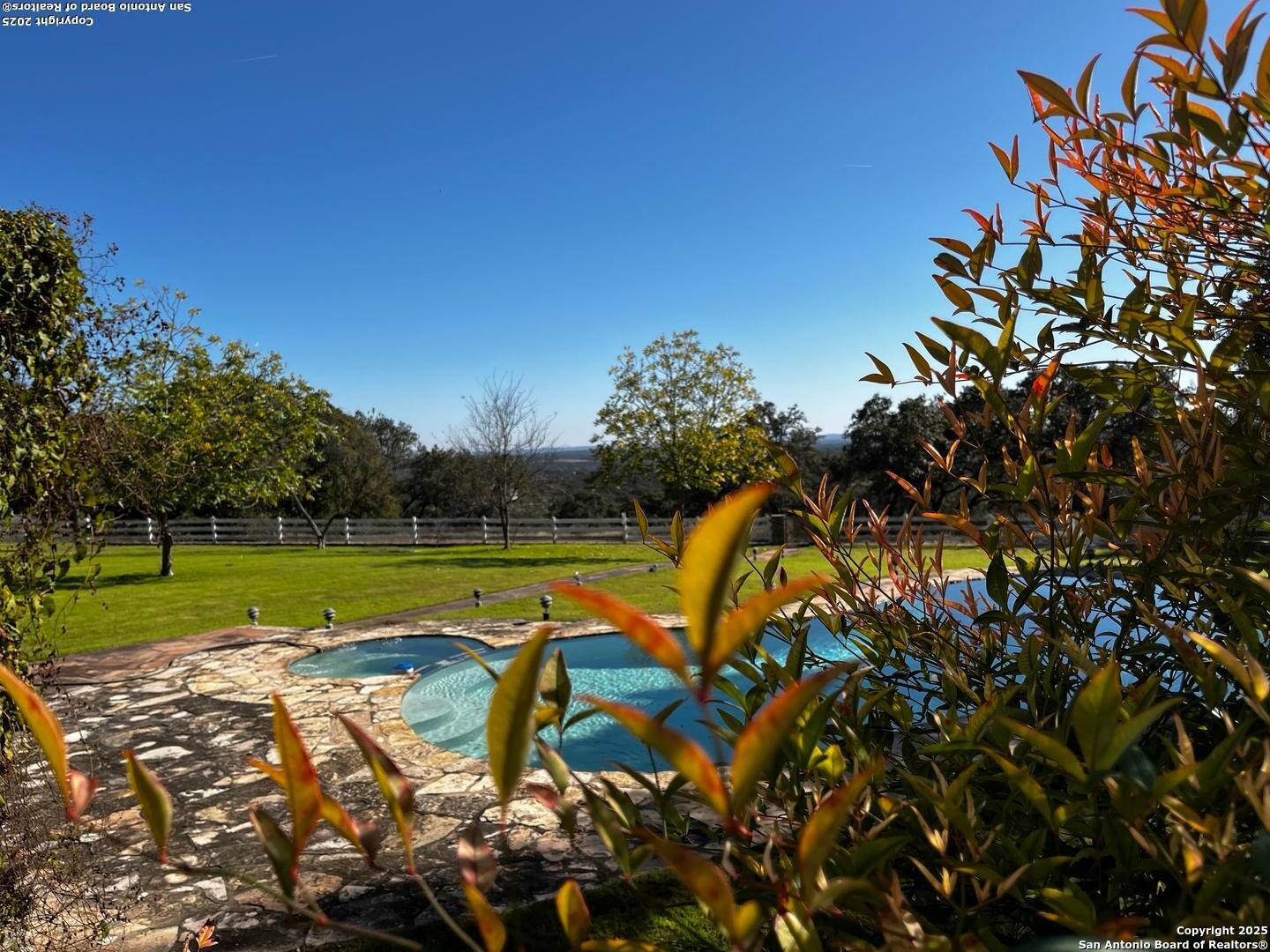 205 Crabapple Road Kendalia, TX 78027 - Photo 6 of 9 a view of a swimming pool with a yard and sitting area