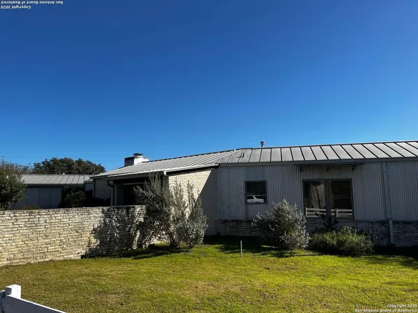 a view of a house with patio next to a yard