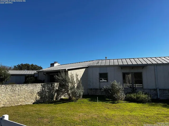 a view of a house with patio next to a yard