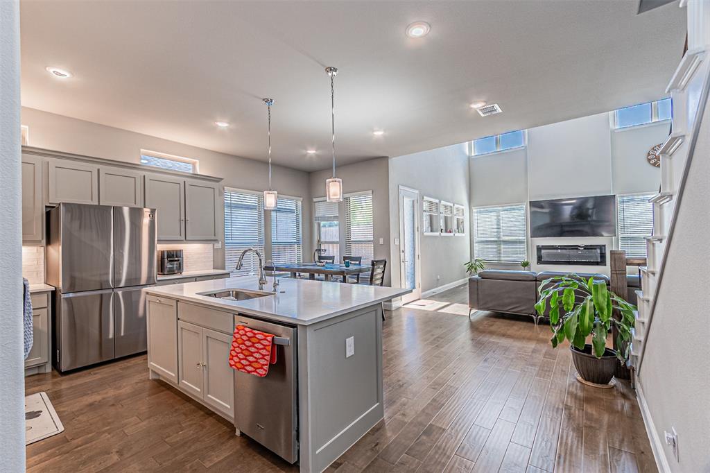 13237 Jonata Street Frisco, TX 75035 - Photo 12 of 39 a kitchen with kitchen island a counter top space a sink stainless steel appliances and wooden floor