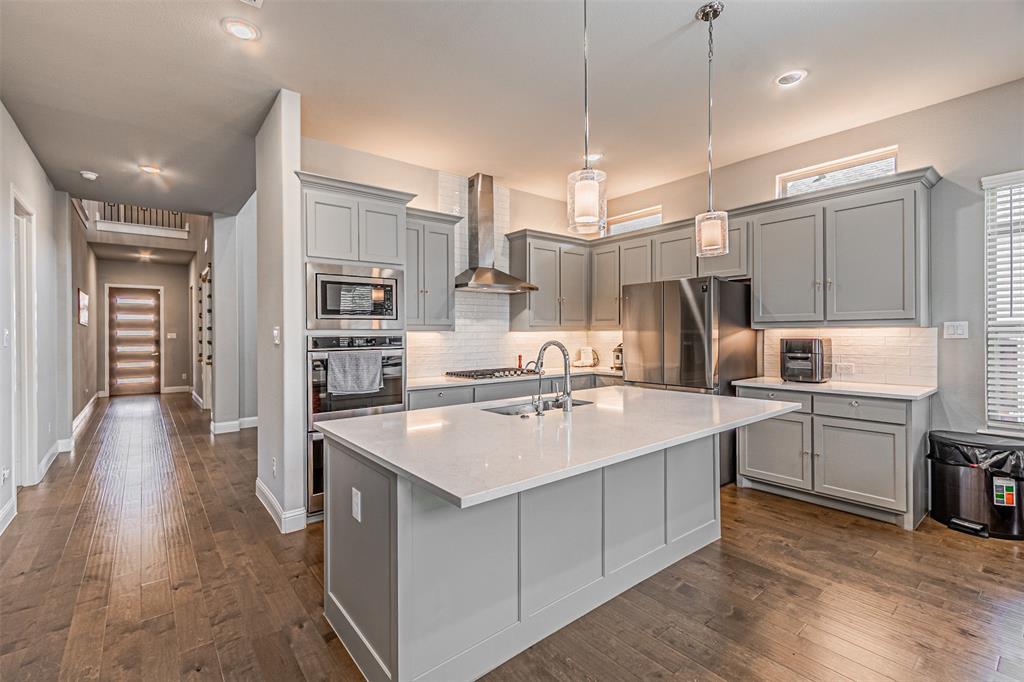 13237 Jonata Street Frisco, TX 75035 - Photo 13 of 39 a kitchen with stainless steel appliances granite countertop a sink a stove and a refrigerator