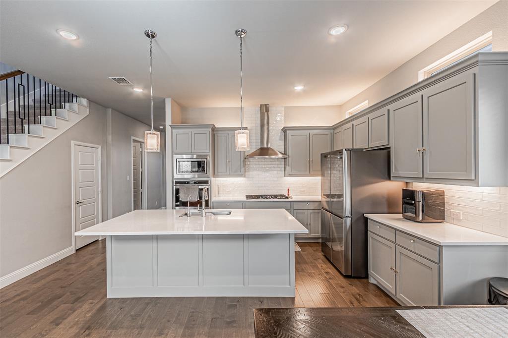 13237 Jonata Street Frisco, TX 75035 - Photo 14 of 39 a large kitchen with kitchen island a sink stainless steel appliances and cabinets