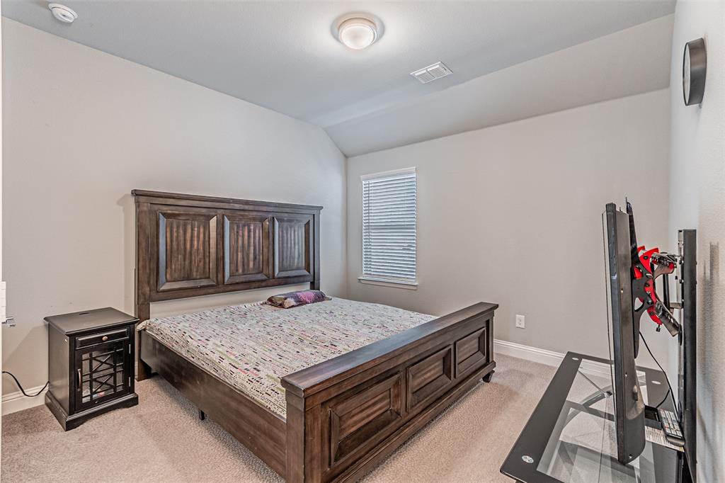 13237 Jonata Street Frisco, TX 75035 - Photo 28 of 39 a view of kitchen island wooden cabinets and refrigerator