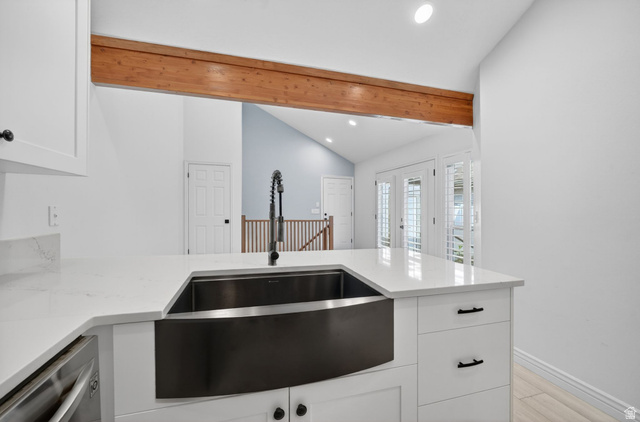6969 South 855 East Midvale, UT 84047 - Photo 5 of 55 Modern kitchen featuring a farmhouse sink with a matte black faucet, white shaker cabinetry, and light quartz countertops