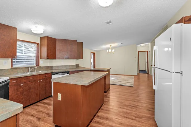 a kitchen with a sink stove top oven and cabinets