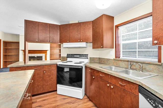 a view of an empty room with a fireplace and a window