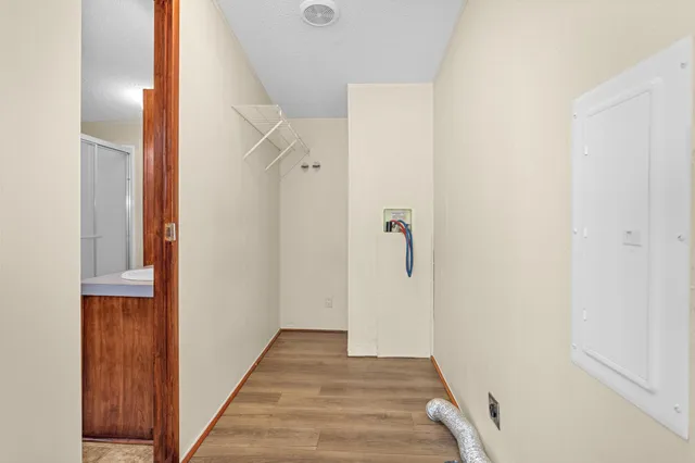 an empty room with chandelier fan and windows