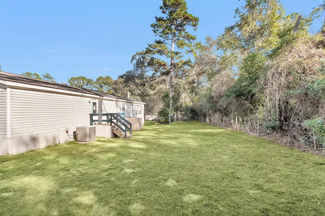 a view of a house with backyard and a tree