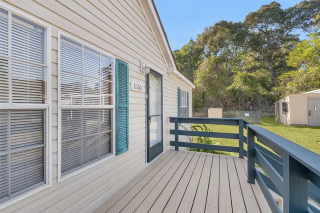 a view of outdoor space with deck and tall trees