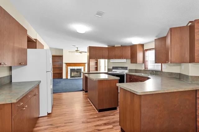a kitchen with stainless steel appliances granite countertop a table chairs sink and cabinets