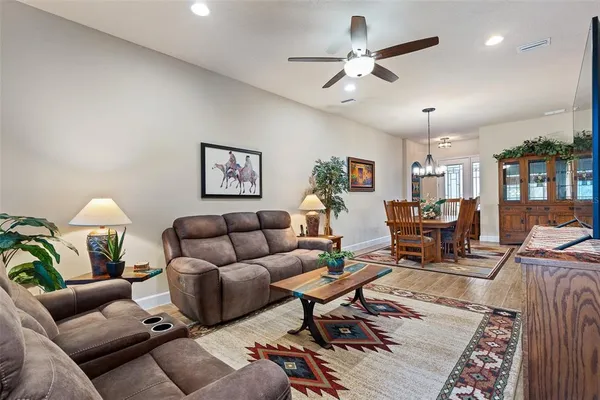 a living room with furniture kitchen view and a chandelier